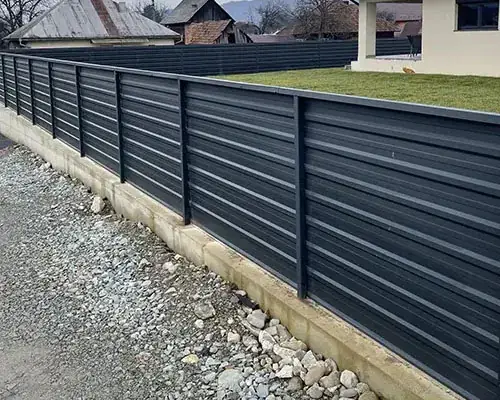 Antracit vízszintes profilos lemez kerítés beton lábazaton, kavicsos sáv mellett