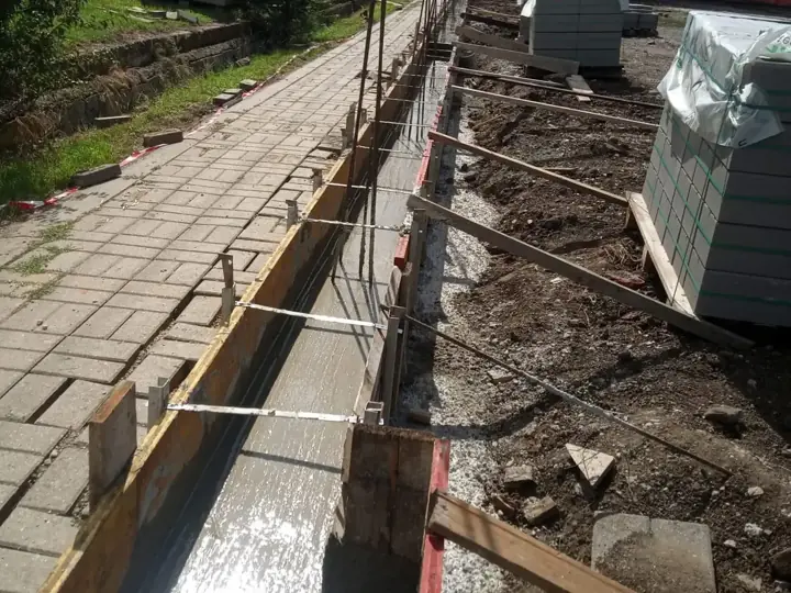Trapézlemez kerítés sávalapjának zsaluzata és kitűzése járdaszegély mellett